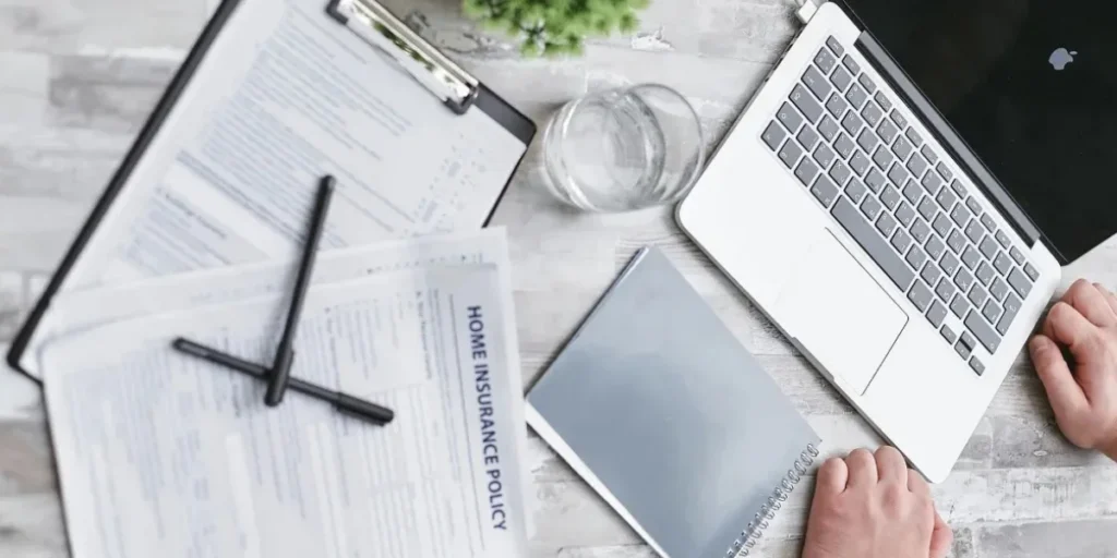 Home insurance policy documents reviewed on a laptop